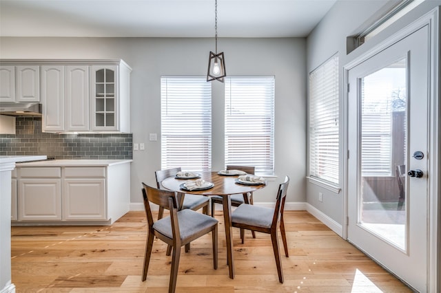 dining area with plenty of natural light, light wood-style flooring, and baseboards