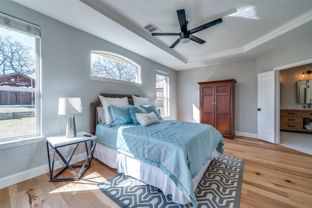 bedroom with a raised ceiling, visible vents, light wood-style flooring, and baseboards