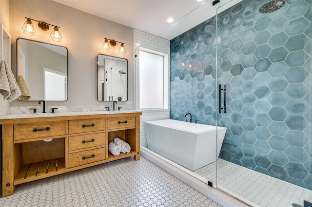 bathroom featuring double vanity, tile walls, a tile shower, a freestanding bath, and a sink