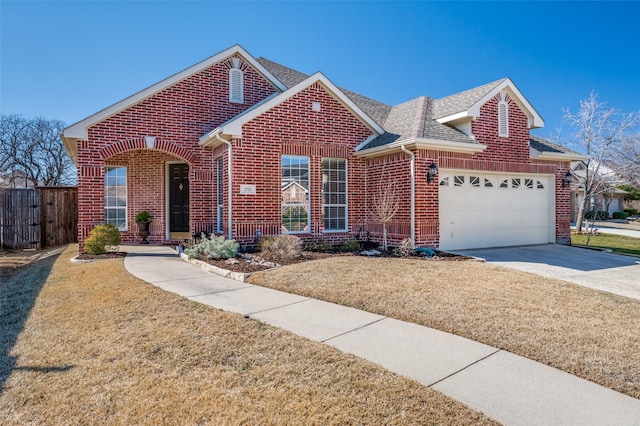 view of front of house with driveway, an attached garage, a shingled roof, and brick siding