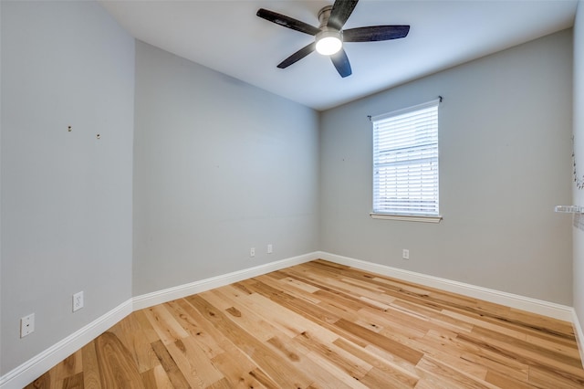 empty room with ceiling fan, baseboards, and wood finished floors