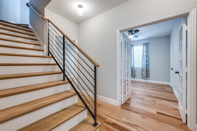 staircase with wood finished floors and baseboards