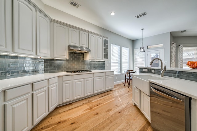 kitchen with under cabinet range hood, visible vents, appliances with stainless steel finishes, and a sink