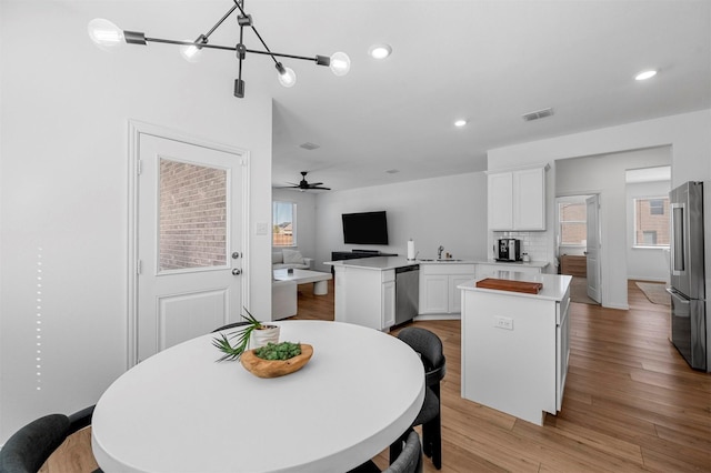 dining space with ceiling fan, light wood-style flooring, visible vents, and recessed lighting