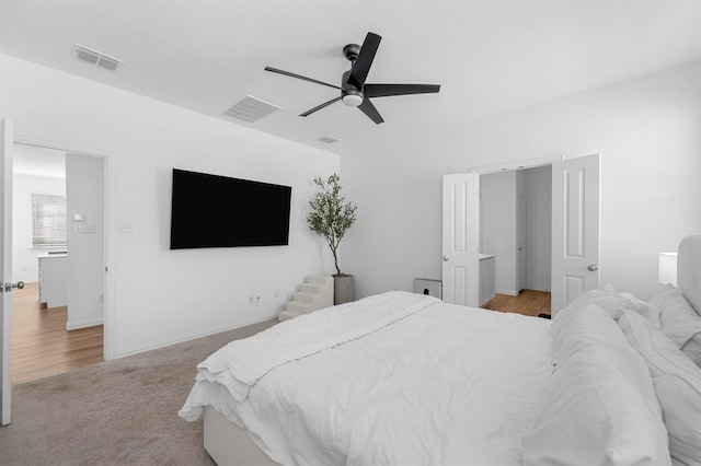 bedroom with light carpet, baseboards, visible vents, and a ceiling fan