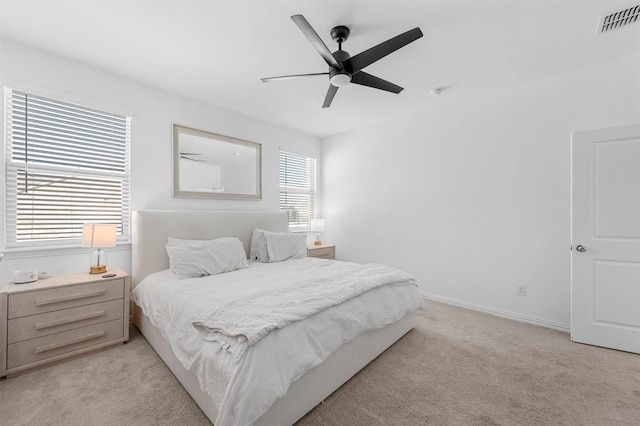 bedroom with light colored carpet, visible vents, ceiling fan, and baseboards