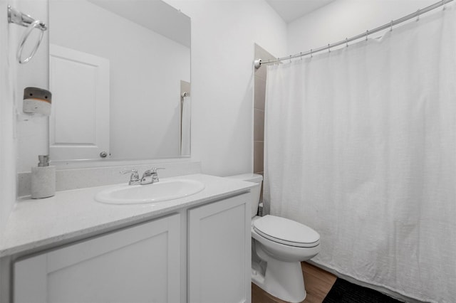 bathroom featuring toilet, curtained shower, wood finished floors, and vanity