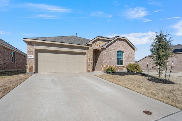 ranch-style home with driveway, a shingled roof, stone siding, an attached garage, and brick siding