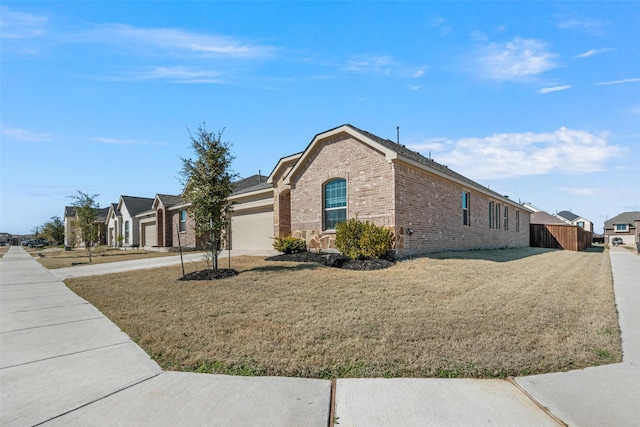 view of property exterior with an attached garage, a yard, concrete driveway, and brick siding