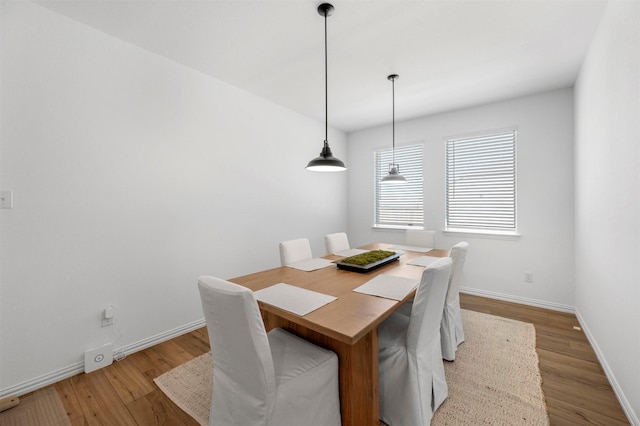 dining area featuring baseboards and light wood finished floors