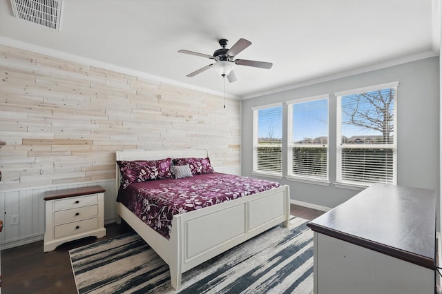 bedroom featuring ornamental molding, dark wood finished floors, visible vents, and baseboards