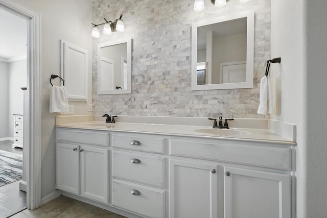 full bath with a sink, baseboards, and double vanity