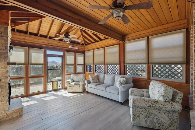 sunroom featuring a ceiling fan, wood ceiling, and beam ceiling