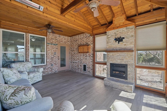 living area with brick wall, a fireplace, wood finished floors, wood ceiling, and beam ceiling