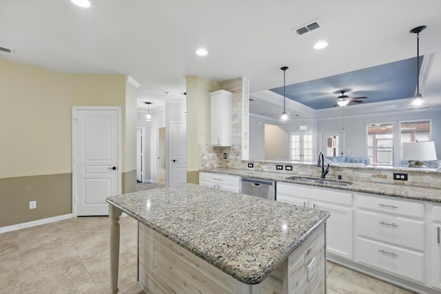 kitchen featuring a sink, visible vents, white cabinets, stainless steel dishwasher, and decorative backsplash