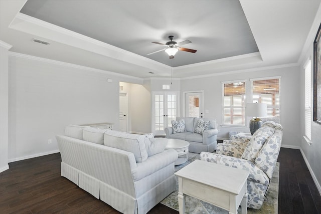 living area featuring dark wood finished floors, a raised ceiling, visible vents, and baseboards