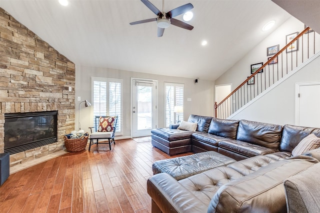 living room featuring recessed lighting, stairway, ceiling fan, a stone fireplace, and wood finished floors