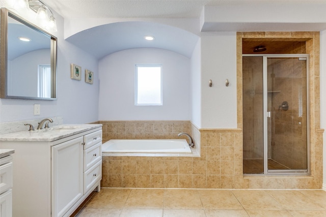 bathroom with a bath, a stall shower, vanity, and tile patterned floors