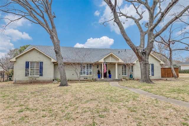 ranch-style house featuring a porch, brick siding, a shingled roof, crawl space, and a front yard