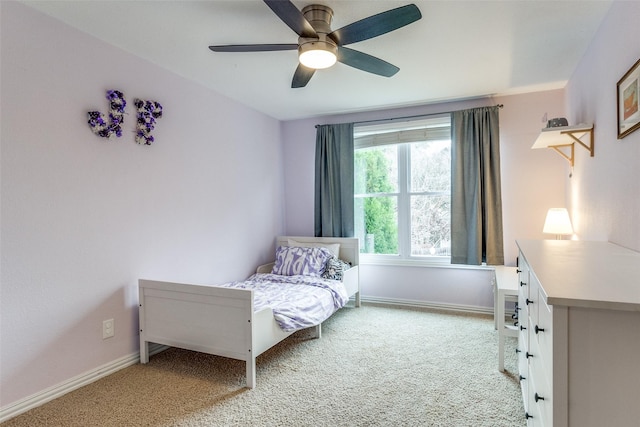 bedroom featuring light colored carpet, ceiling fan, and baseboards