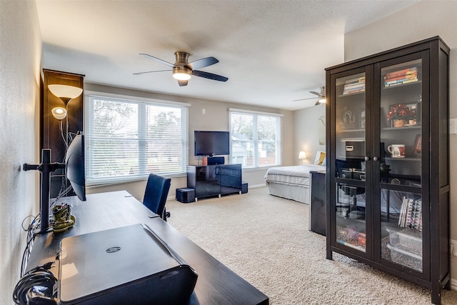 carpeted home office featuring ceiling fan and baseboards