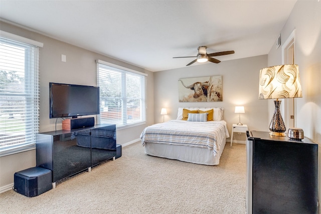 bedroom with ceiling fan, multiple windows, carpet flooring, and baseboards