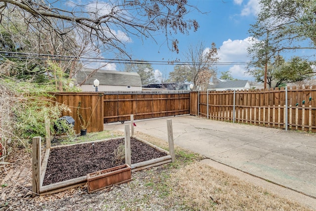 view of yard with a garden, a patio area, and a fenced backyard