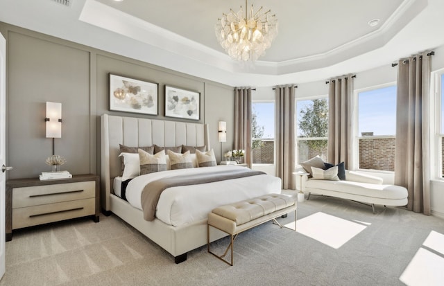 carpeted bedroom with a chandelier, a tray ceiling, and crown molding