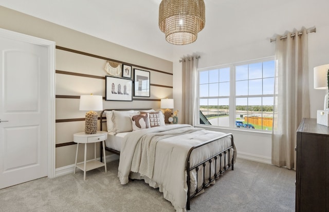 bedroom with light carpet, baseboards, and a notable chandelier