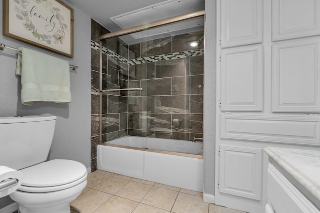 bathroom with combined bath / shower with glass door, vanity, toilet, and tile patterned floors