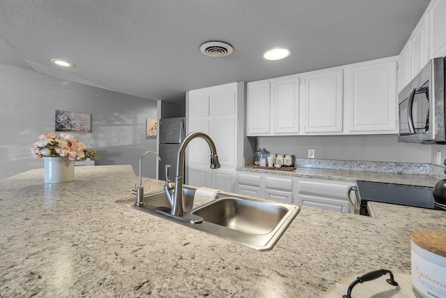 kitchen featuring recessed lighting, a sink, visible vents, white cabinetry, and appliances with stainless steel finishes