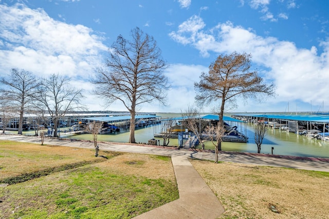 dock area with a water view and a lawn