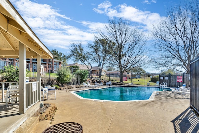 pool with a patio and fence