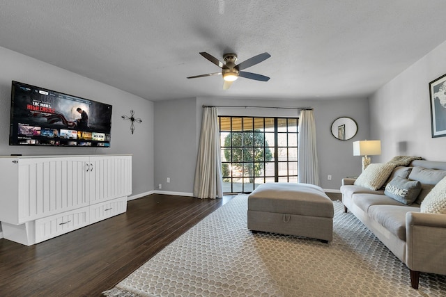 living room with a textured ceiling, wood finished floors, a ceiling fan, and baseboards