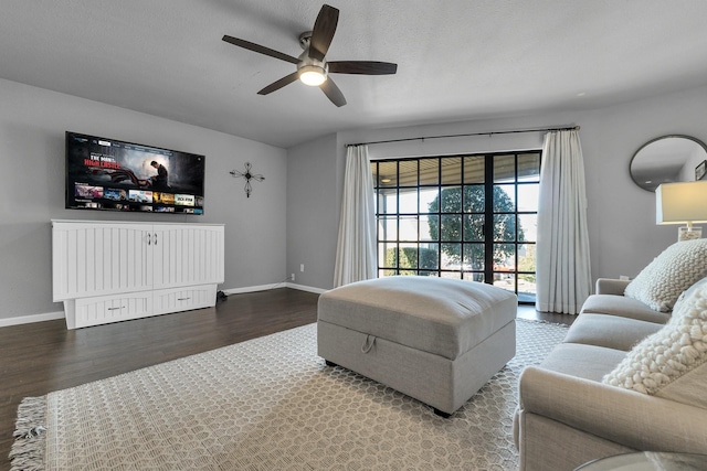 living area with ceiling fan, baseboards, and wood finished floors