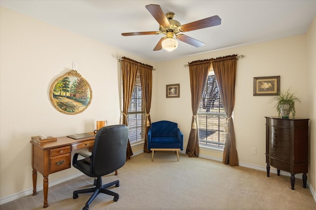 office space with light colored carpet, ceiling fan, and baseboards