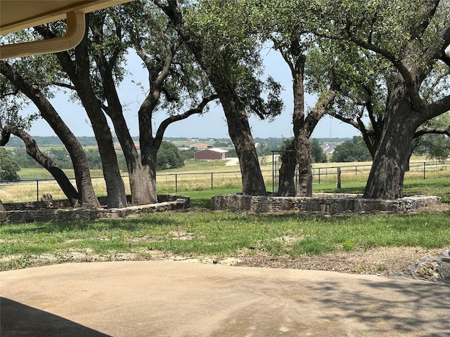 view of yard with a rural view and fence