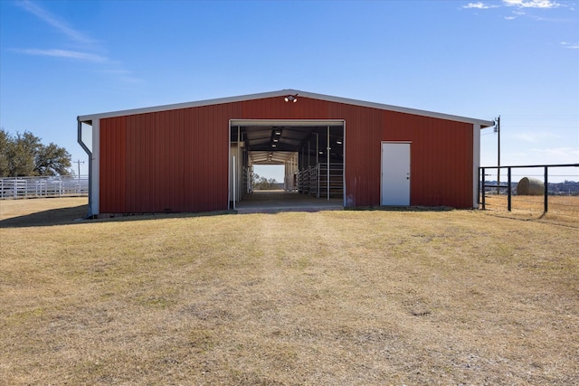 view of pole building with a yard and fence