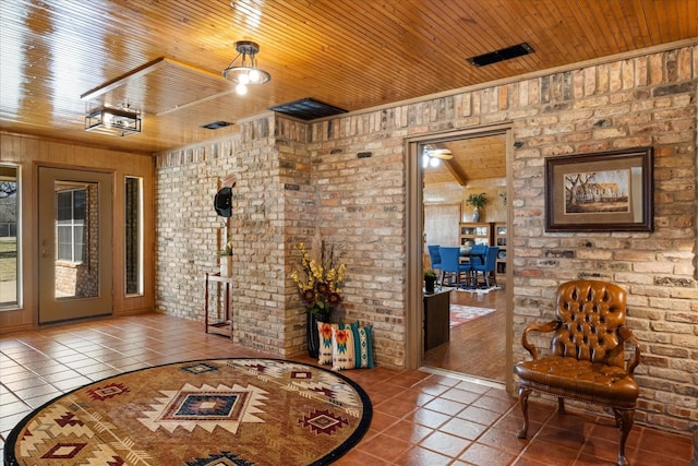 interior space with wood ceiling, brick wall, and tile patterned flooring