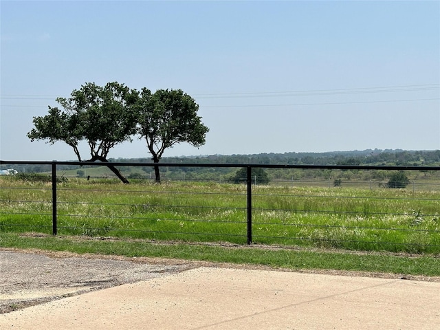 view of yard with a rural view and fence