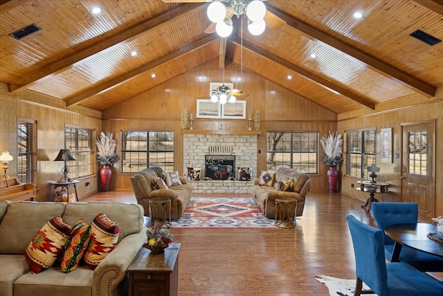 living area with plenty of natural light, wooden ceiling, a fireplace, and ceiling fan