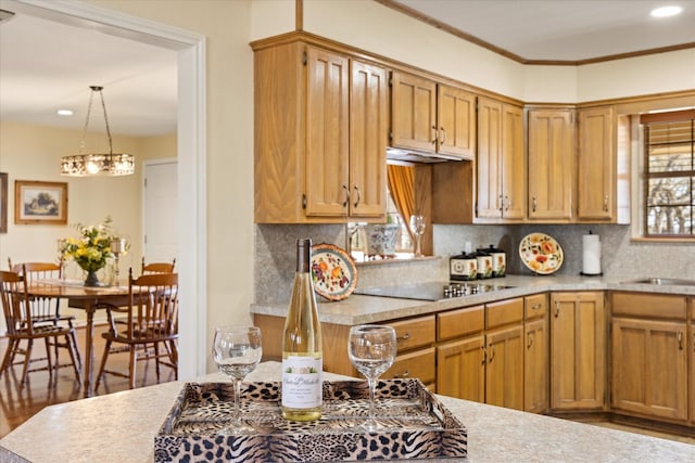 kitchen with tasteful backsplash, crown molding, black electric cooktop, and light countertops