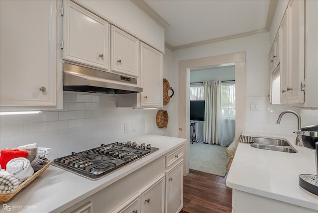 kitchen with white cabinets, light countertops, under cabinet range hood, stainless steel gas cooktop, and a sink