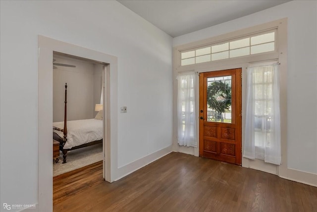 foyer with dark wood finished floors and baseboards