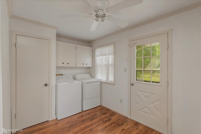 washroom featuring wood finished floors, plenty of natural light, washing machine and clothes dryer, and cabinet space