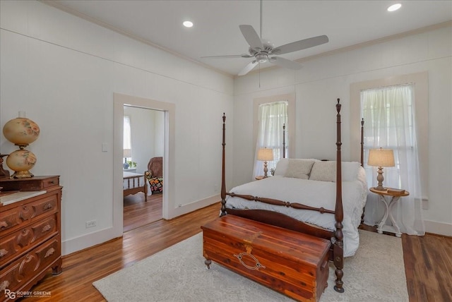 bedroom with ornamental molding, recessed lighting, baseboards, and wood finished floors