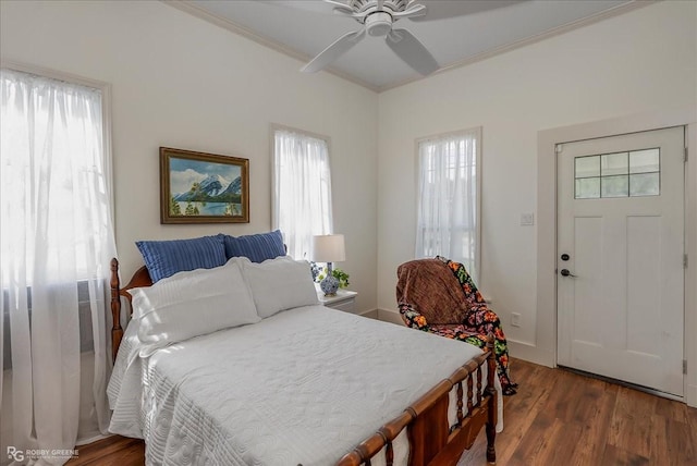 bedroom with crown molding, baseboards, ceiling fan, and wood finished floors