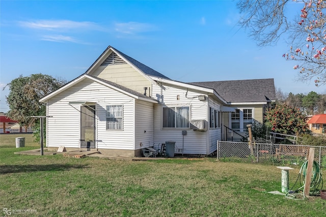 rear view of property with a shingled roof, cooling unit, a lawn, and fence