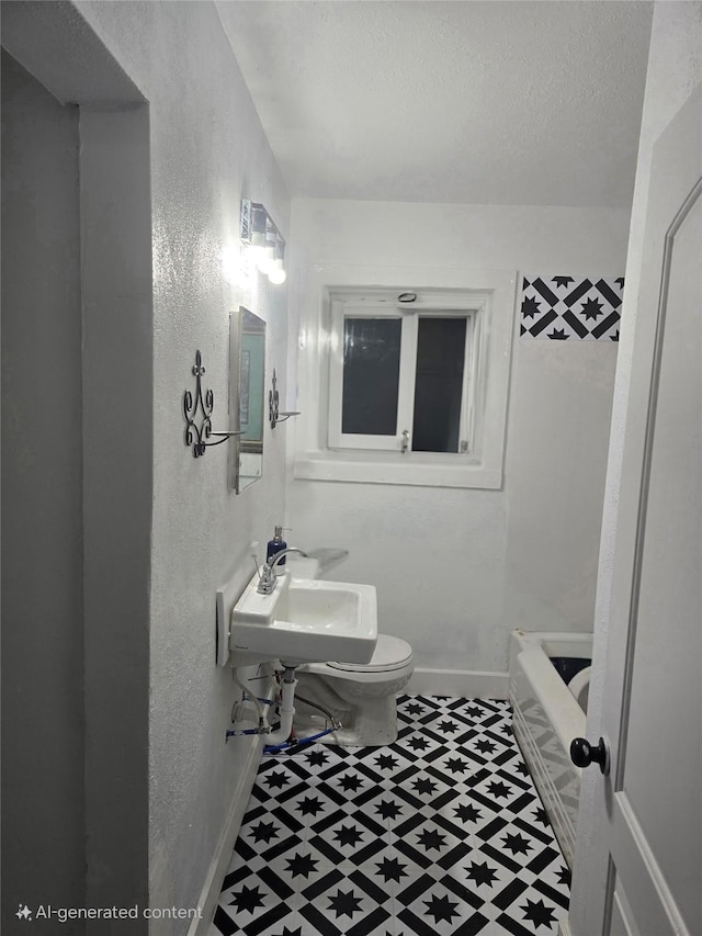 full bath featuring toilet, baseboards, a textured ceiling, and a textured wall