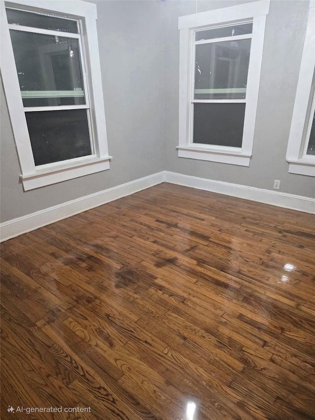 empty room featuring dark wood finished floors and baseboards